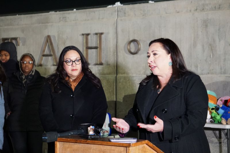Two Latina legislators speak from a podium in front of the Utah State Capitol