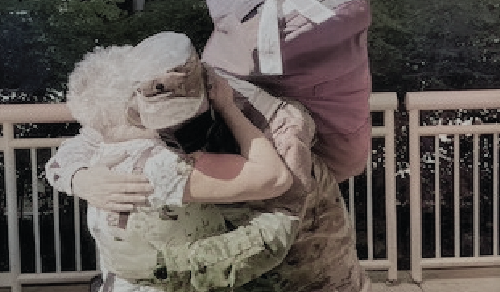 A veteran, wearing his uniform, hugs an elderly family member.